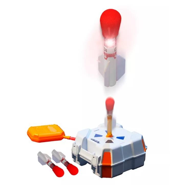 A stomp rocket set with a launch pad, a foot stomper, and three rockets; one rocket is shown mid-launch with a red illuminated tip.