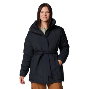 A person is wearing a black belted puffer jacket with a hood and brown pants.