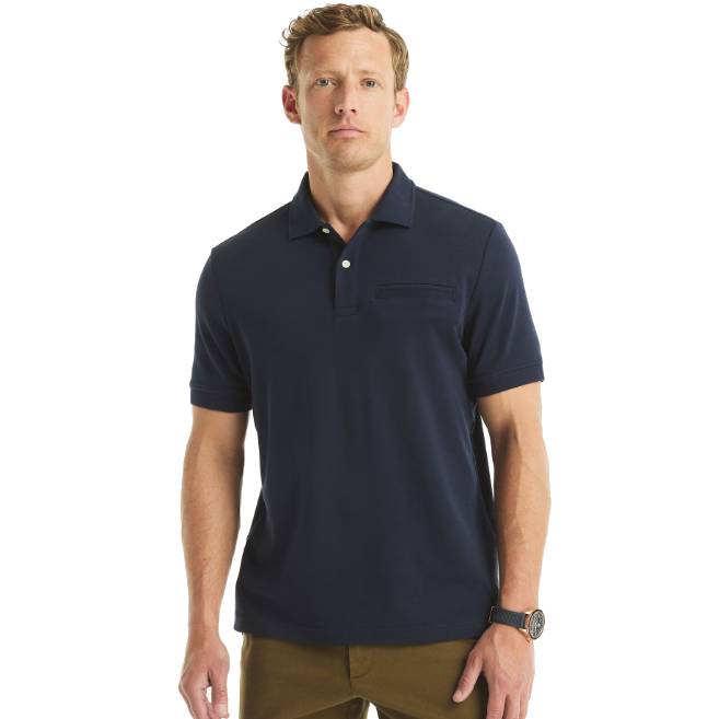 A man is wearing a navy blue polo shirt with brown pants and a wristwatch.