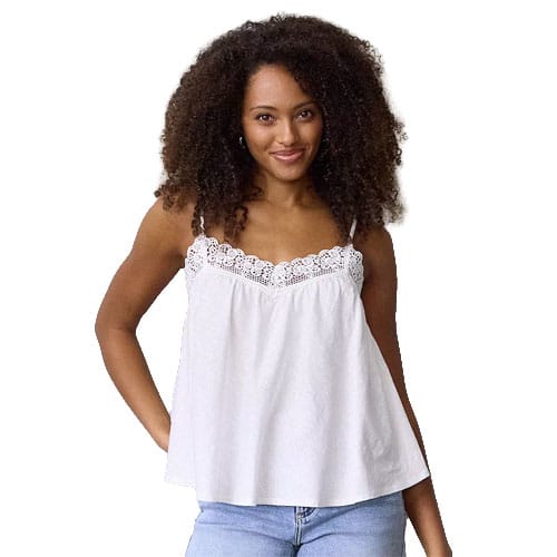 A woman is wearing a white sleeveless top with lace trim, paired with light blue jeans.