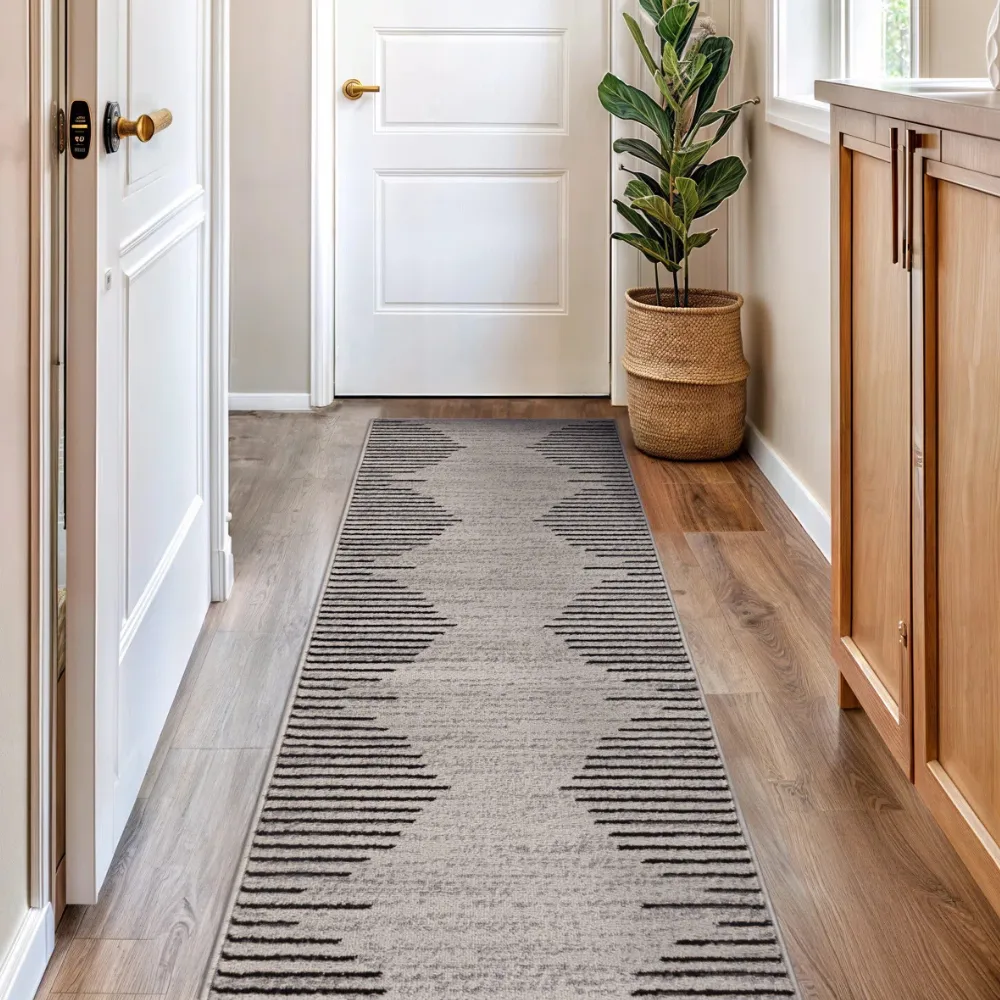 Hallway with a geometric-patterned runner rug and a potted plant in a woven basket beside a white door.