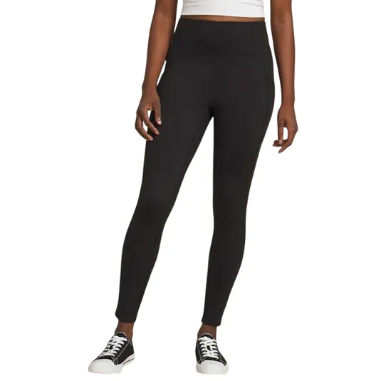 Black high-waisted leggings with side pockets, paired with black and white sneakers and a white cropped top.