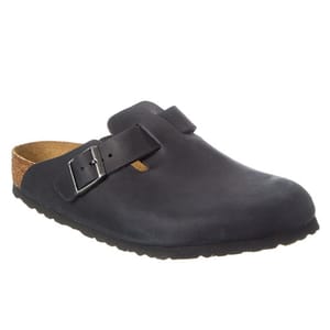 A dark-colored slip-on shoe with a cork footbed and an adjustable buckle strap across the top.
