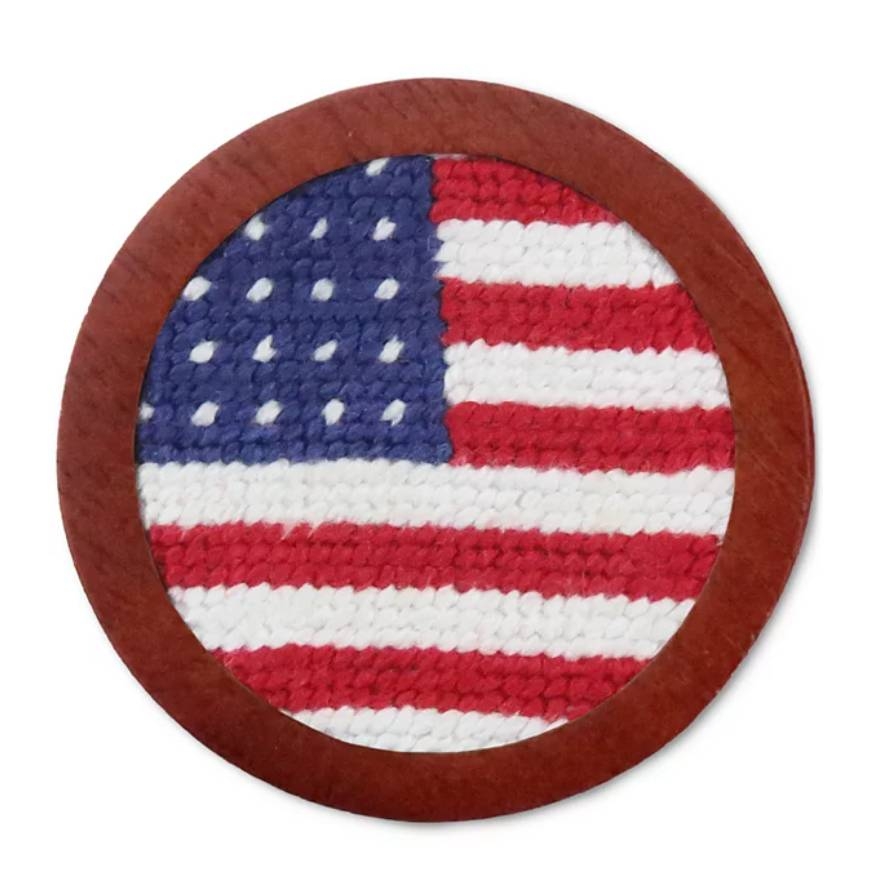 A circular coaster featuring a woven American flag pattern with red, white, and blue colors, bordered by a brown ring.