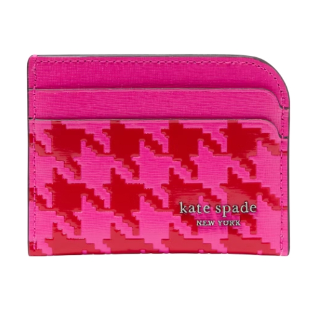 A vibrant pink and red houndstooth card holder from Kate Spade New York, featuring multiple card slots and a glossy finish with the brand's logo.