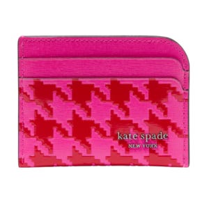 A vibrant pink and red houndstooth card holder from Kate Spade New York, featuring multiple card slots and a glossy finish with the brand's logo.