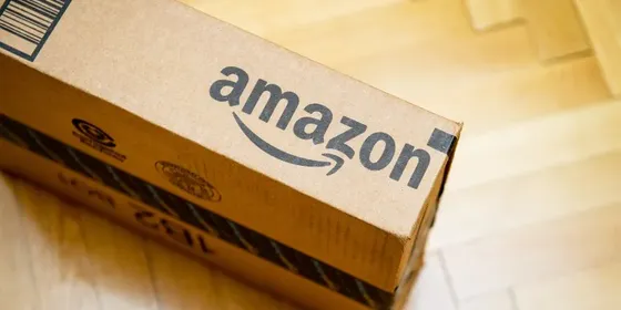 an Amazon cardboard box on a wooden floor