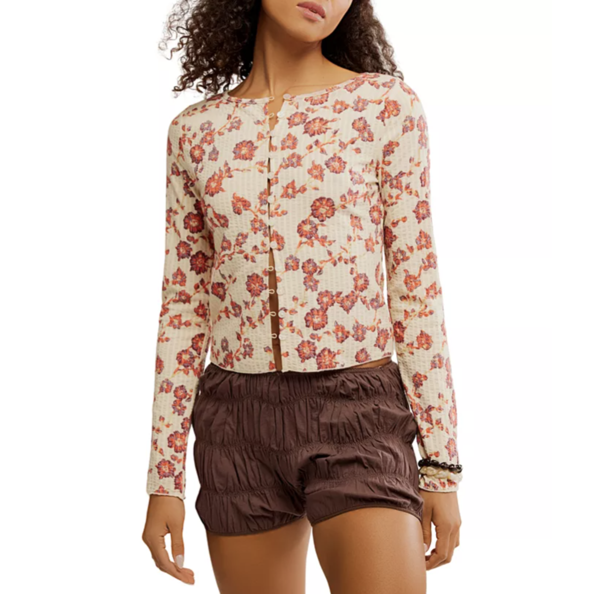 A long-sleeve floral button-down top paired with brown textured shorts.