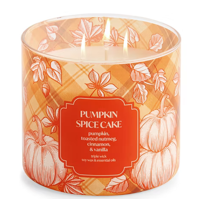 Candle labeled \“Pumpkin Spice Cake\“ with notes of pumpkin, toasted nutmeg, cinnamon, and vanilla, featuring a triple wick design. Decorated with autumn leaf and pumpkin patterns.