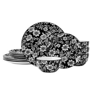 A dinnerware set featuring plates and bowls with a black background and white floral pattern.