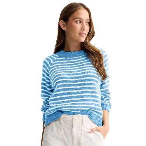 Woman wearing a blue and white striped sweater with light-colored pants.