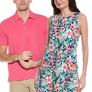 A man wears a short-sleeve, collared pink shirt with beige pants, and a woman in a sleeveless dress features a colorful, floral pattern.