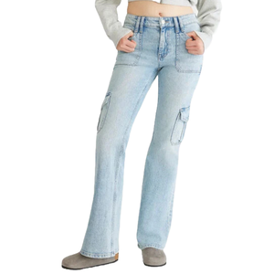 Light blue flare cargo jeans with side pockets, featuring a high waist and button closure, paired with a cropped light gray sweatshirt and gray boots.
