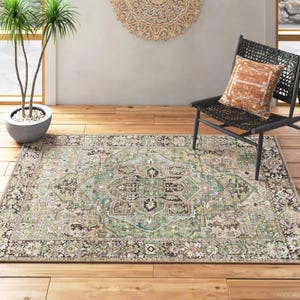 A decorative area rug with intricate patterns, paired with a black chair featuring a patterned cushion on a wooden floor.