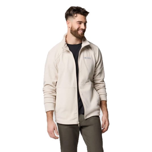 A man is wearing a light-colored Columbia fleece jacket with a high collar, along with a dark shirt and khaki pants.