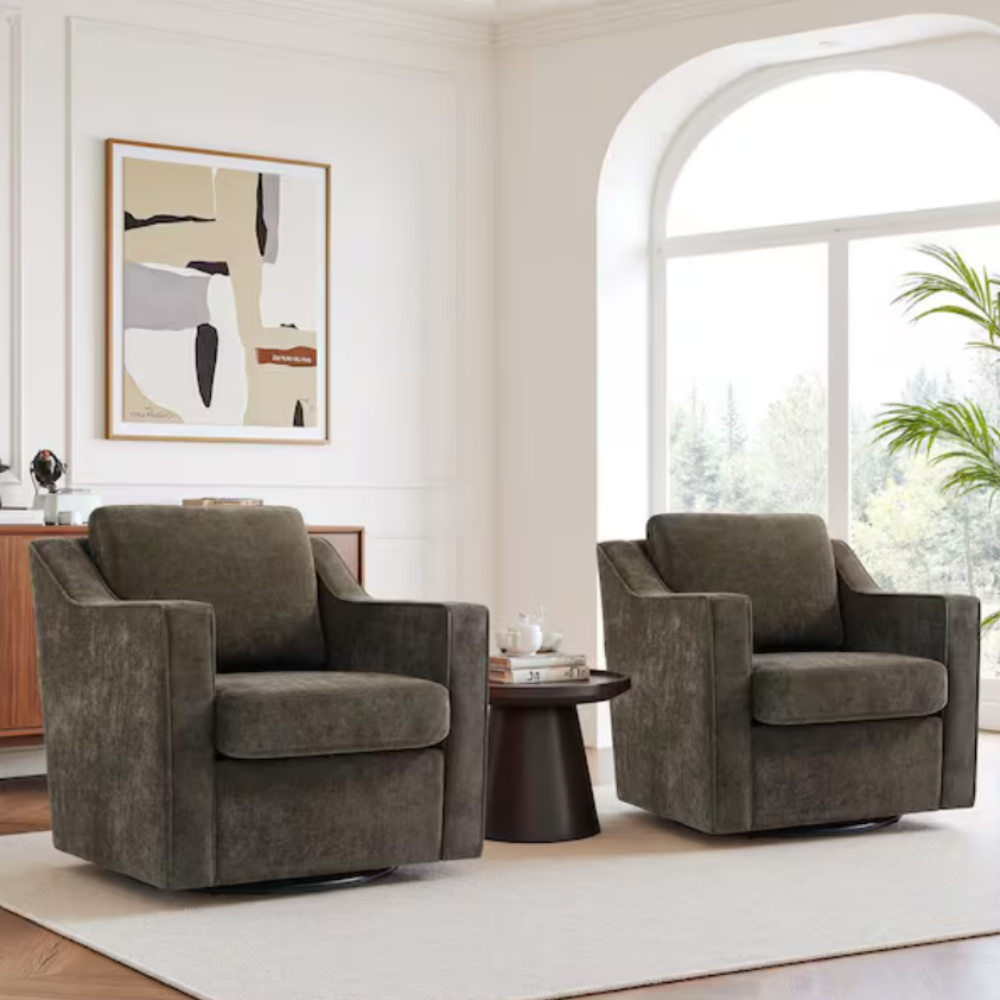 Two dark brown swivel chairs are positioned in a living room, flanking a dark round side table with a white cup and books on it. A modern abstract painting and large window complete the elegant setting.
