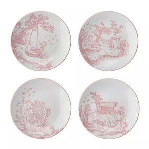 Set of four decorative plates featuring red toile-style designs with pastoral scenes, including children playing, a doghouse, and a person picking flowers.