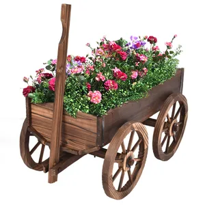 Wooden cart planter with two large spoked wheels, filled with vibrant pink and purple flowers and greenery.