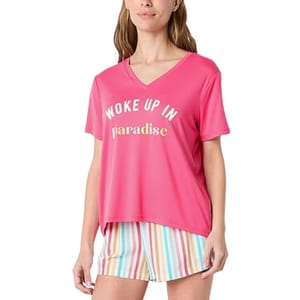 Pink short-sleeve pajama top with a V-neck, featuring the phrase \“Woke Up In Paradise\“ printed on the front in block letters. Paired with striped shorts in pastel colors.