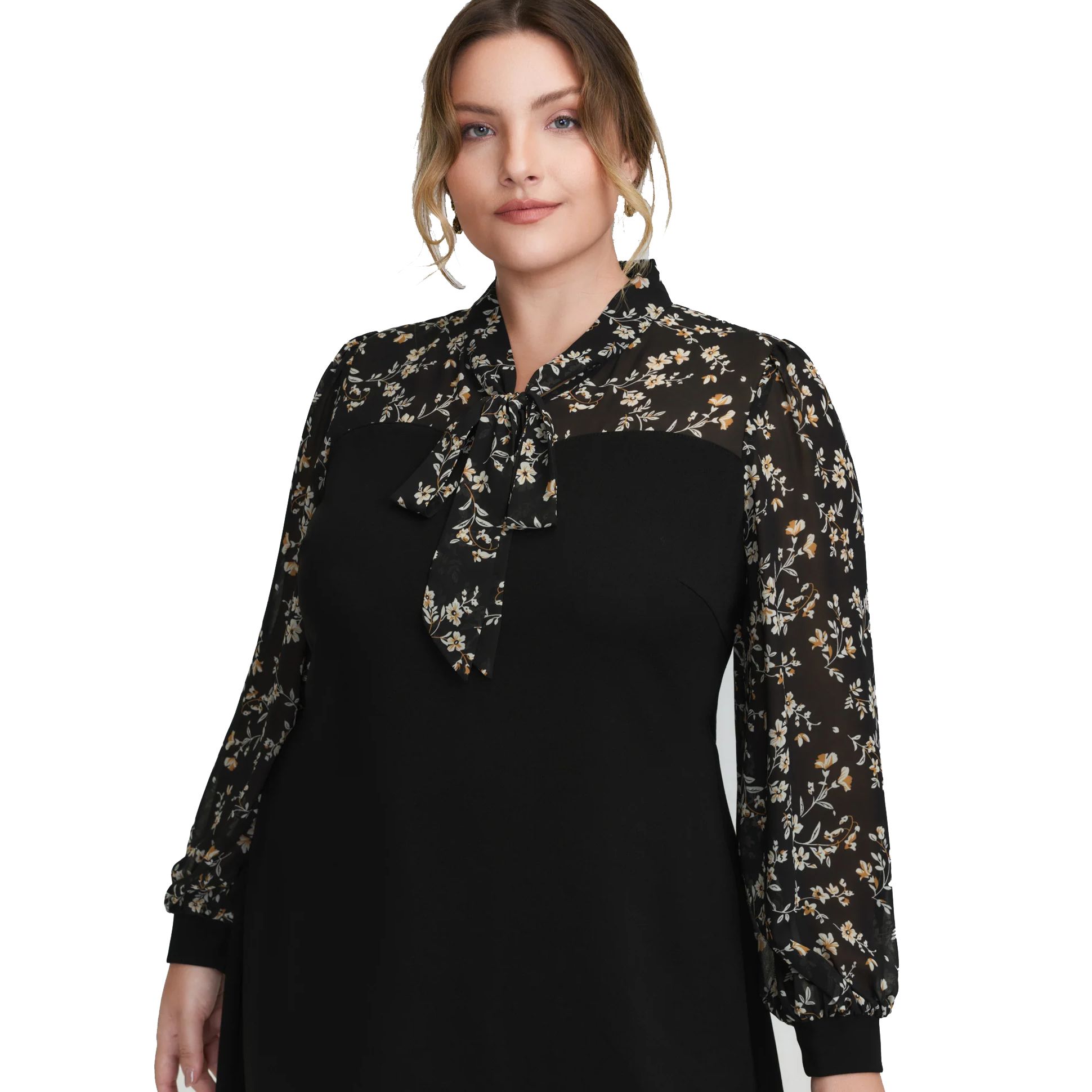 A woman is wearing a black dress with sheer floral-patterned sleeves and a matching bow tie at the neckline.