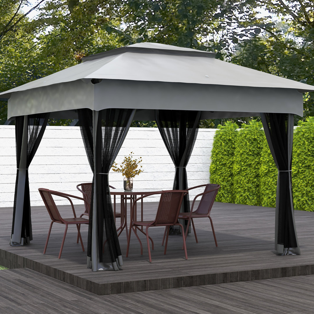 11' Steel Gazebo with Mesh Walls features a sturdy frame, black mesh curtains, and a dual-tiered grey canopy. It includes a round table with four chairs under the gazebo, situated on a wooden platform surrounded by a white fence and greenery.