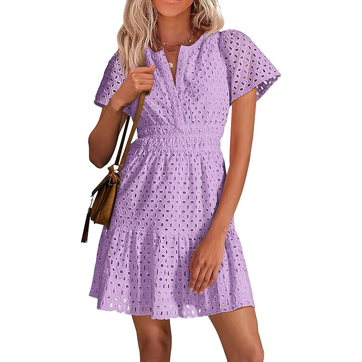 A woman is wearing a short-sleeve lavender eyelet mini dress with a cinched waist, V-neck, and flared hem, paired with a brown crossbody bag.