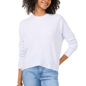 A Vince Camuto crewneck sweater in a soft, light blue shade with a relaxed fit and ribbed cuffs, paired with light blue jeans.