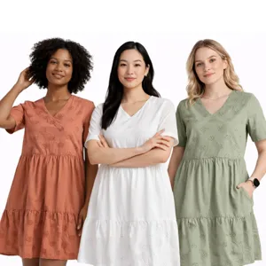 Three women wearing short-sleeve, knee-length dresses in rust orange, white, and sage green, each with a subtle floral pattern and tiered skirt.