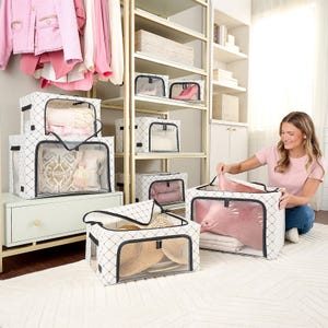 A woman is organizing a variety of clear window storage bags in different sizes with clothing and accessories inside.