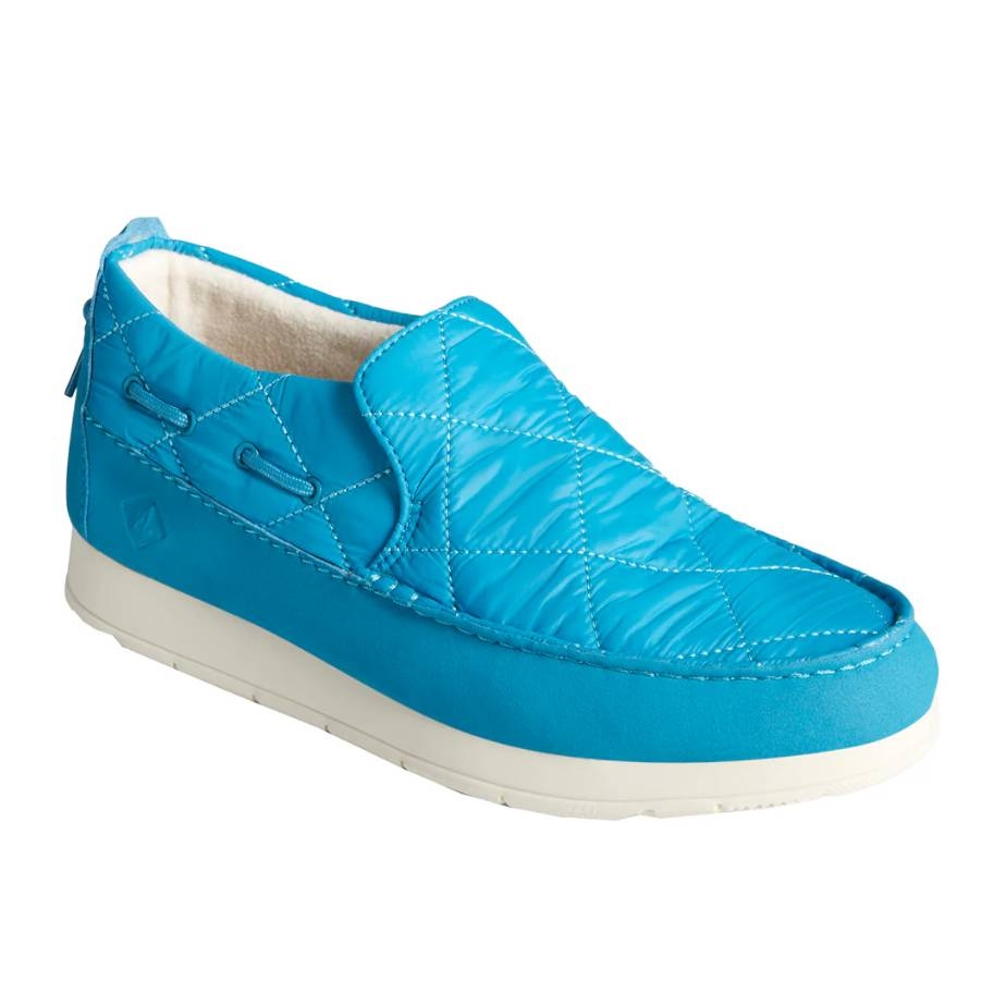 Bright blue quilted slip-on shoes with white soles, featuring side lacing details and a warm fleece lining.