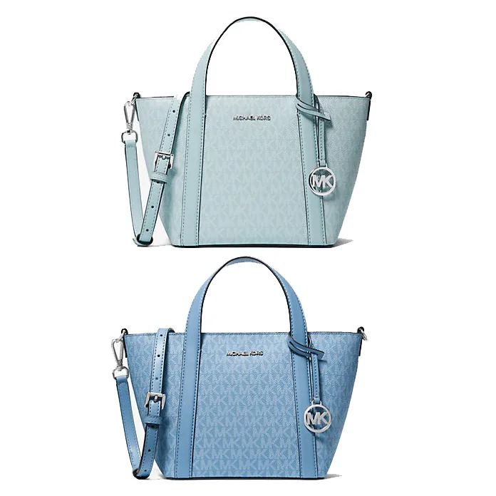 A small tote bag in light blue with a monogram pattern, featuring dual handles, a detachable strap, and a prominent logo charm.
