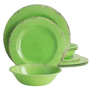 A set of green dishware with a distressed edge design, including plates and a bowl.