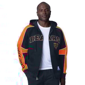 A man is wearing a black and orange Chicago Bears full-zip hoodie with bold team lettering and logo.
