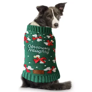 A dog wears a green Christmas sweater with \“Obviously Naughty\“ embroidered on it, featuring red bows and white snowflakes.