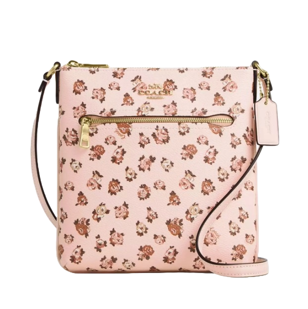 A pink floral print Coach crossbody bag with a front zip pocket and adjustable strap, accented with gold hardware and a hanging tag.