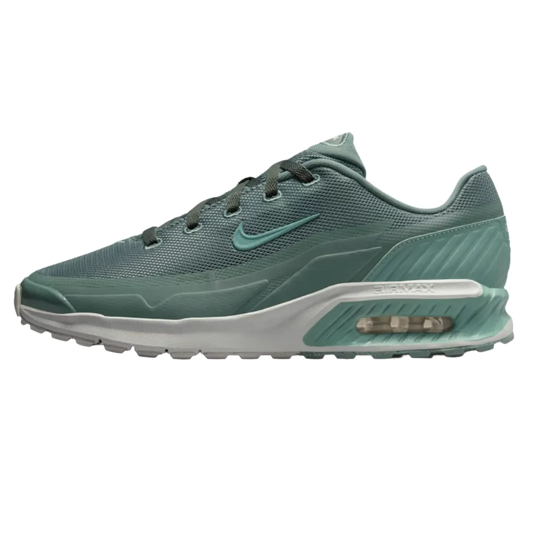 A green Nike Air Max shoe featuring mesh upper, visible air cushioning, and a textured midsole for added support.