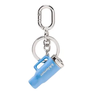 A blue Lululemon keychain shaped like a mini water bottle, attached to a silver keyring and a clasp.