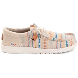 A casual slip-on shoe with a colorful, woven pattern featuring stripes and geometric designs in blue, orange, and red hues on a light tan background. The shoe has a white sole and lace details.