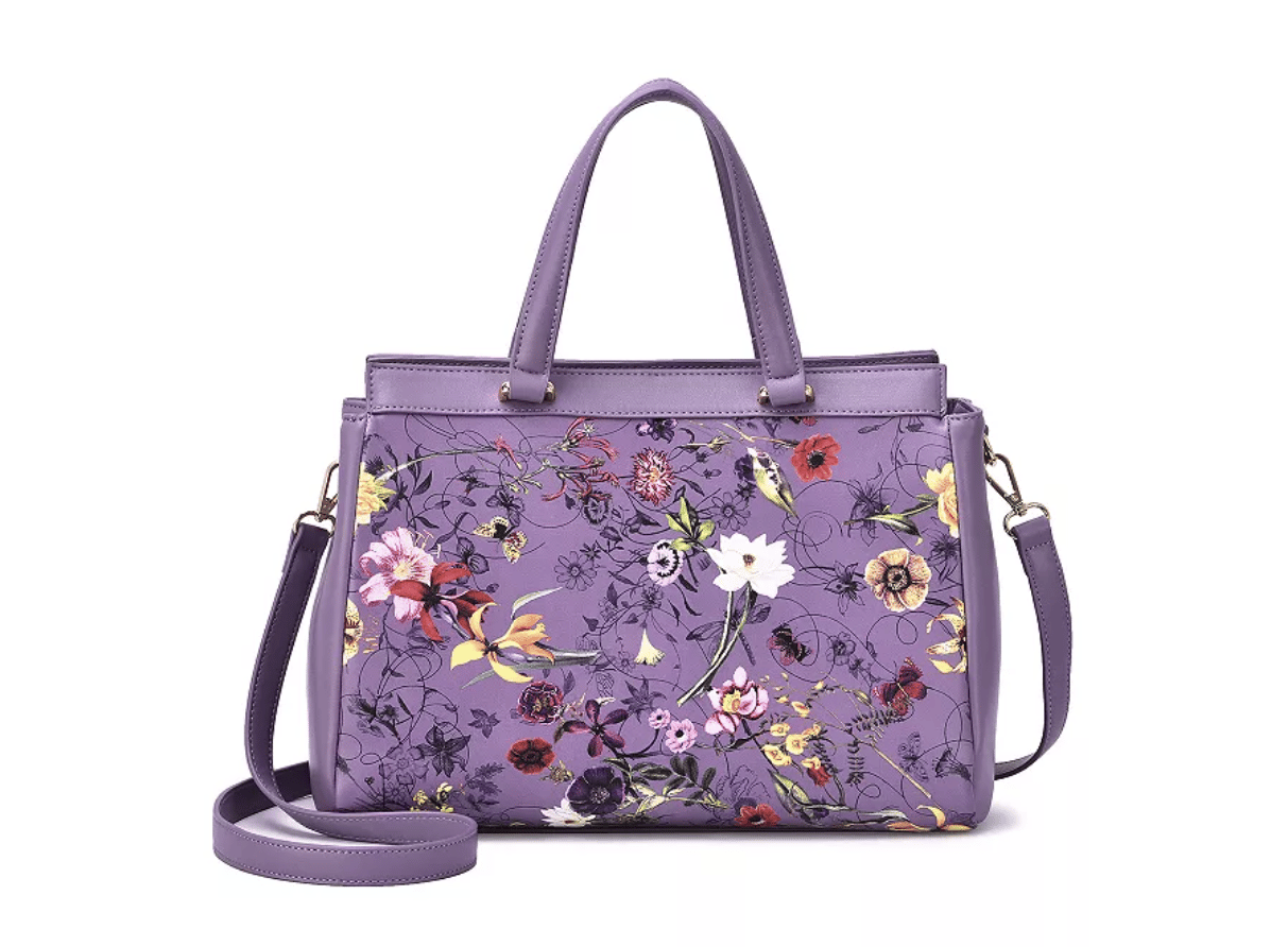 A purple handbag with a colorful floral pattern, featuring both handles and a detachable shoulder strap.