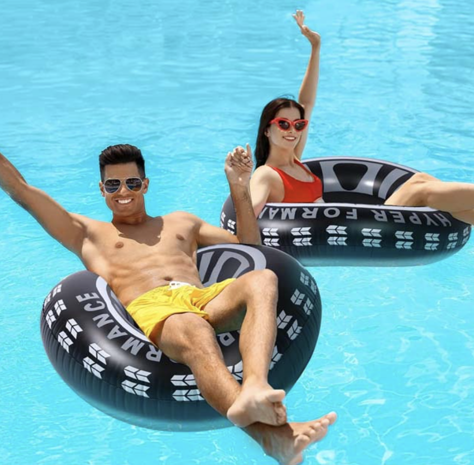 Two people floating on inflatable pool rings in clear blue water.