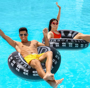 Two people floating on inflatable pool rings in clear blue water.