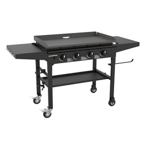Blackstone 36\“ Omnivore Griddle features a flat griddle top with four control knobs, side shelves, and a lower storage shelf, all mounted on a wheeled frame for mobility.