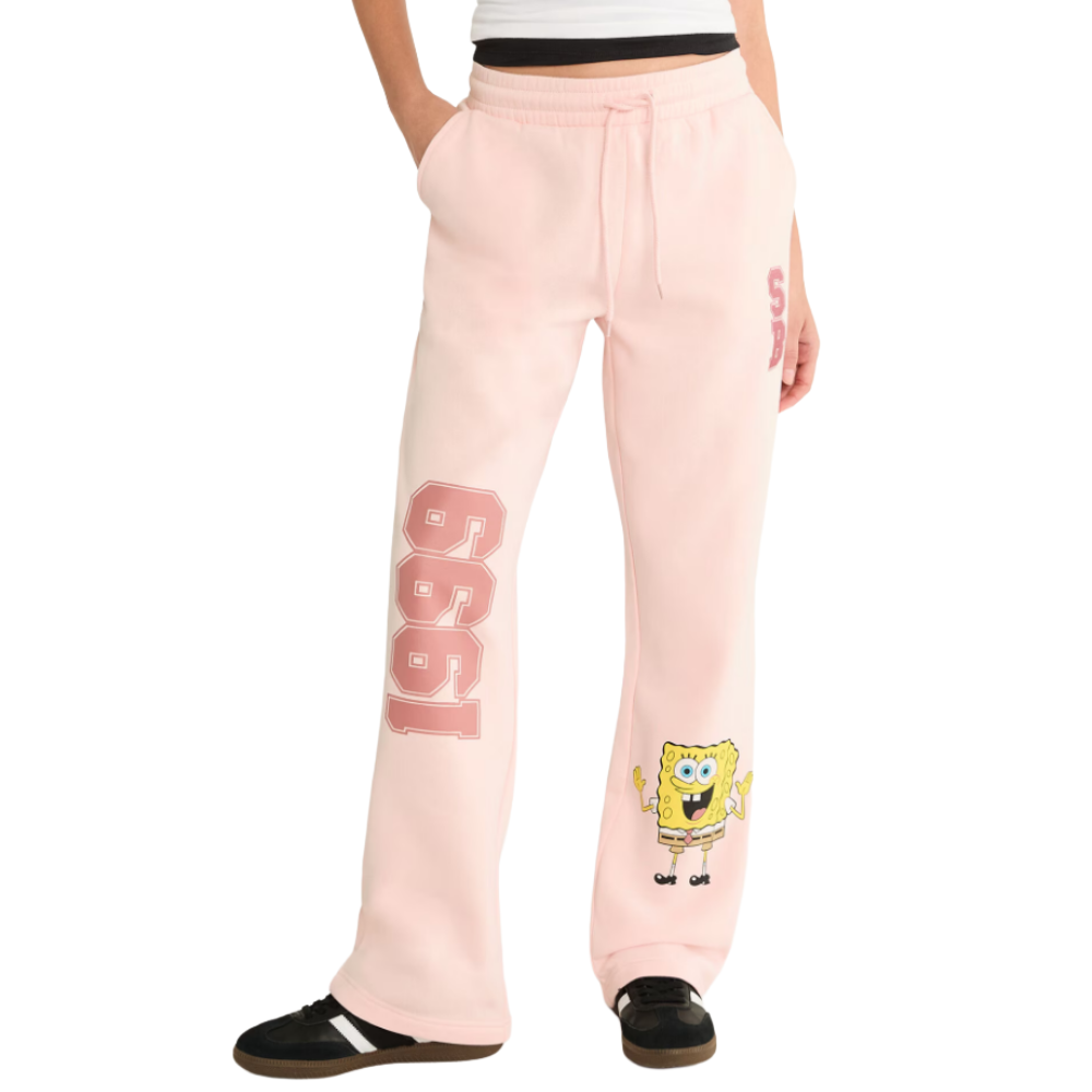 Pink sweatpants feature \“1999\“ and SpongeBob SquarePants graphics, paired with black sneakers.