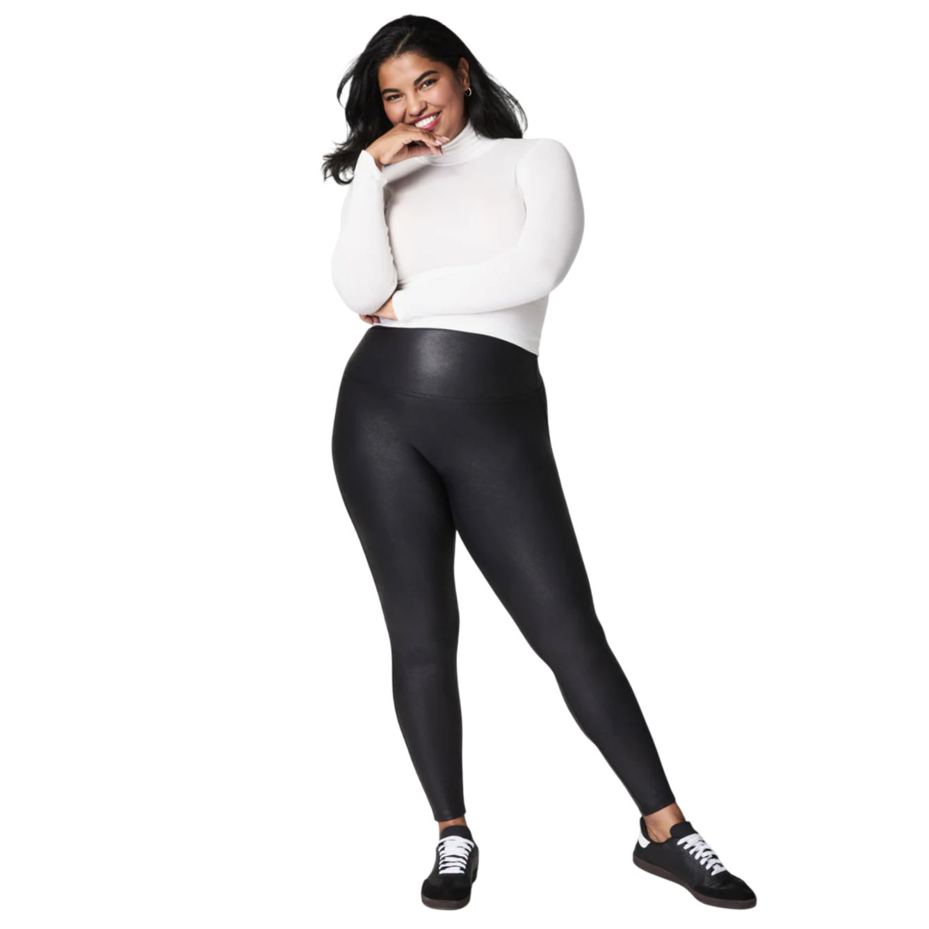 A person is shown wearing black leggings paired with a white turtleneck and black sneakers.