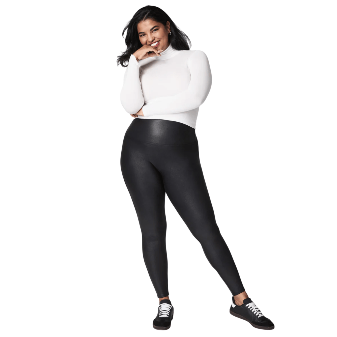 A person is shown wearing black leggings paired with a white turtleneck and black sneakers.