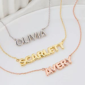 Three personalized name necklaces in silver, gold, and rose gold finishes.