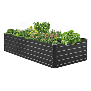 A black, rectangular, metal raised garden bed with various vegetables and flowers growing inside.