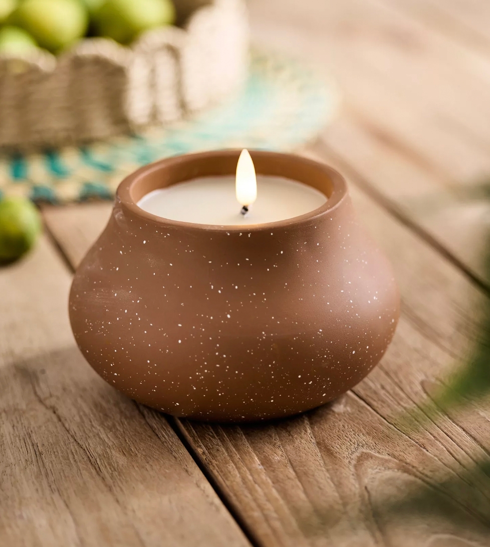 A flameless candle with a glowing LED light is enclosed within a spherical, matte-finished holder with small, star-like speckles.