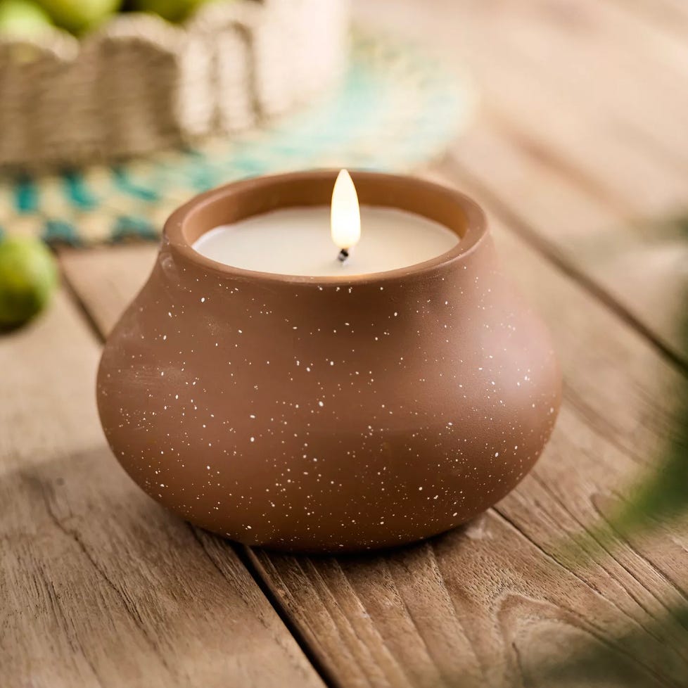 A flameless candle with a glowing LED light is enclosed within a spherical, matte-finished holder with small, star-like speckles.