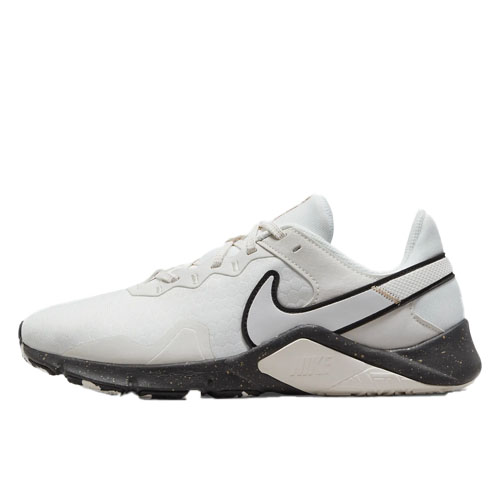 A white Nike sneaker with a black swoosh, featuring a textured upper, lace-up closure, and a speckled black sole.
